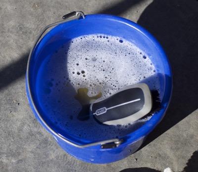 bucket of soapy water with hard brush