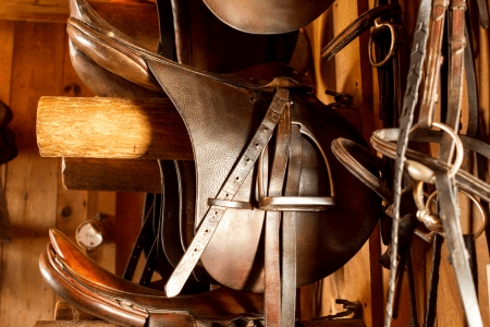 older jumping saddle on a round saddle rack 